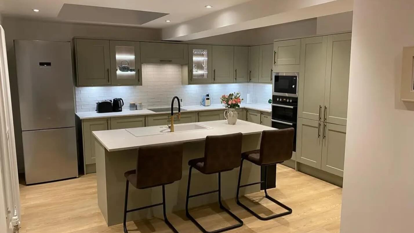 Modern kitchen installation by TM Joinery in Glasgow, featuring sage green cabinetry and island